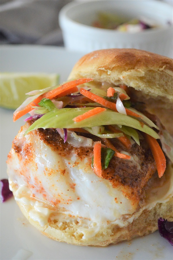 Baked Cod Sandwich- A delicious fish sandwich piled high with fresh slaw and a lime aioli sauce. Perfect for a quick weeknight dinner.