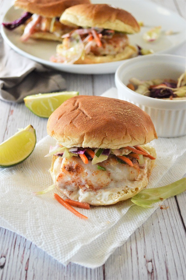 Baked Cod Sandwich- A delicious fish sandwich piled high with fresh slaw and a lime aioli sauce. Perfect for a quick weeknight dinner.
