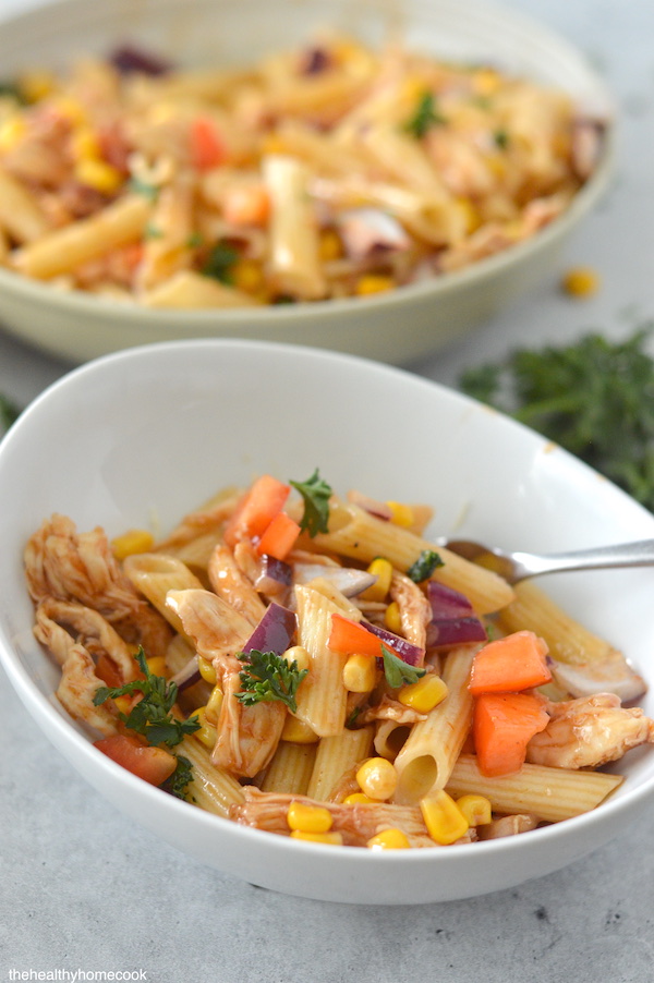 Tender chicken, crunchy vegetables and a sweet, tangy barbecue vinaigrette in a small serving bowl with fork.