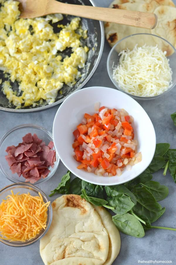 These homemade Mini Breakfast Pizzas are topped with your favorite morning essentials. Perfect for breakfast or dinner!
