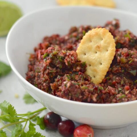 This Spicy Cranberry Salsa is easy to make and full of holiday flavor! Save this recipe for a crowd-pleasing dip.