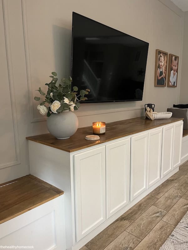 Image of finished entertainment center. Different angle, with lit candle and flower on top.