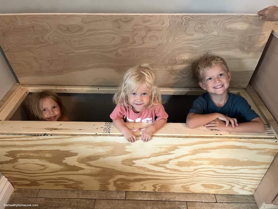 Process image of three kids inside storage bench.