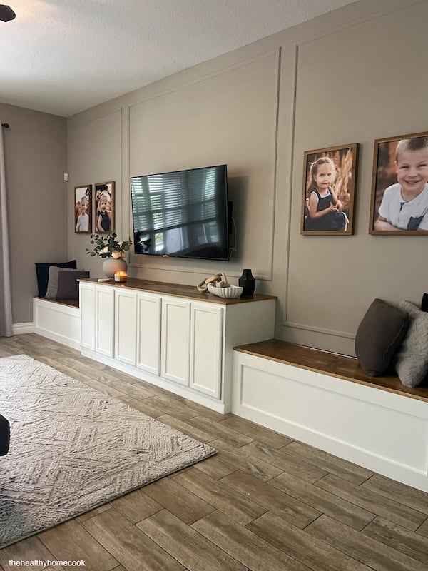 Closer shot of finished entertainment center with decor and tv hung on wall.