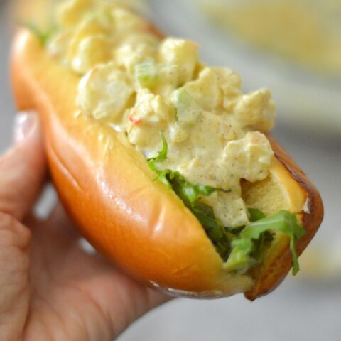 Close shot of hand holding Curried Shrimp Rolls.