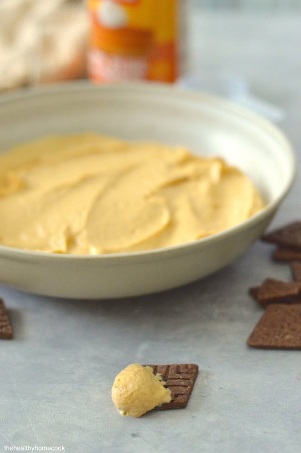 Image of cracker with Creamy Pumpkin Protein dip on top.